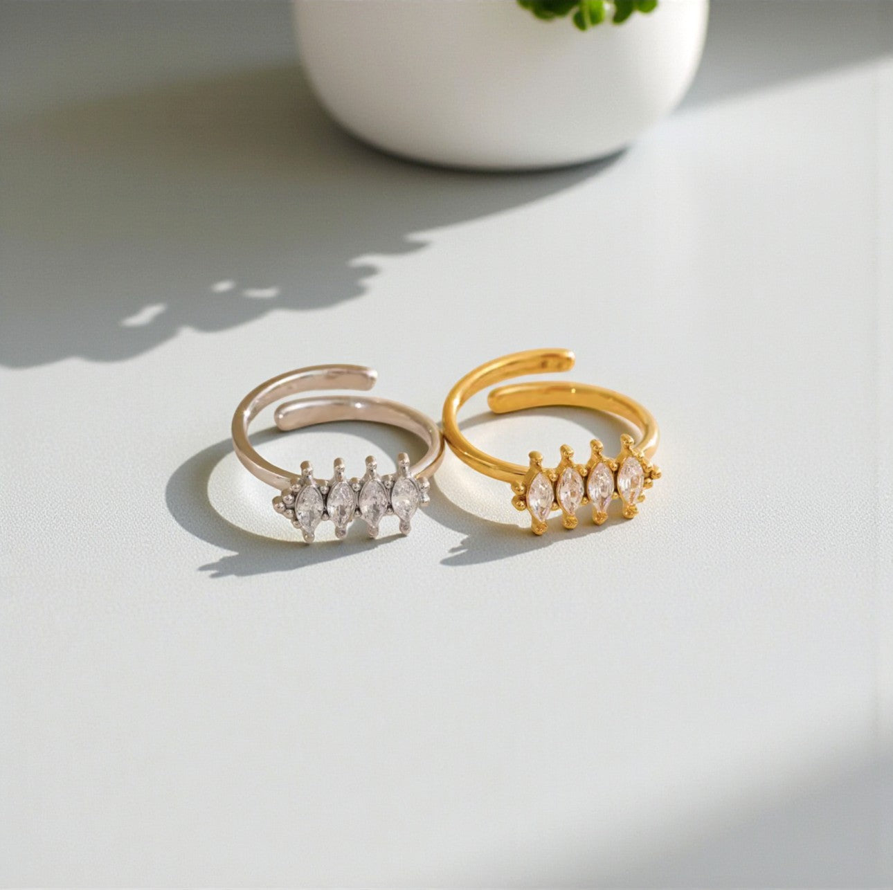 Two gold and silver rings with diamond accents on a light surface.