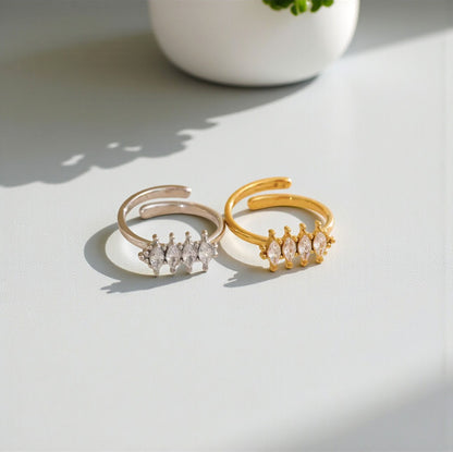 Two gold and silver rings with diamond accents on a light surface.