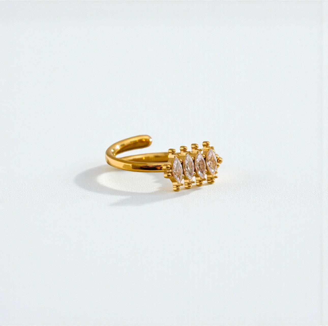 Gold ring with embedded stones on a light gray background