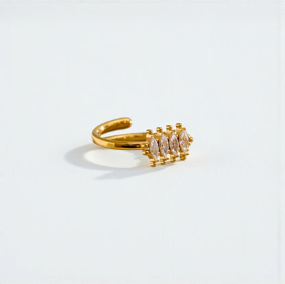Gold ring with embedded stones on a light gray background