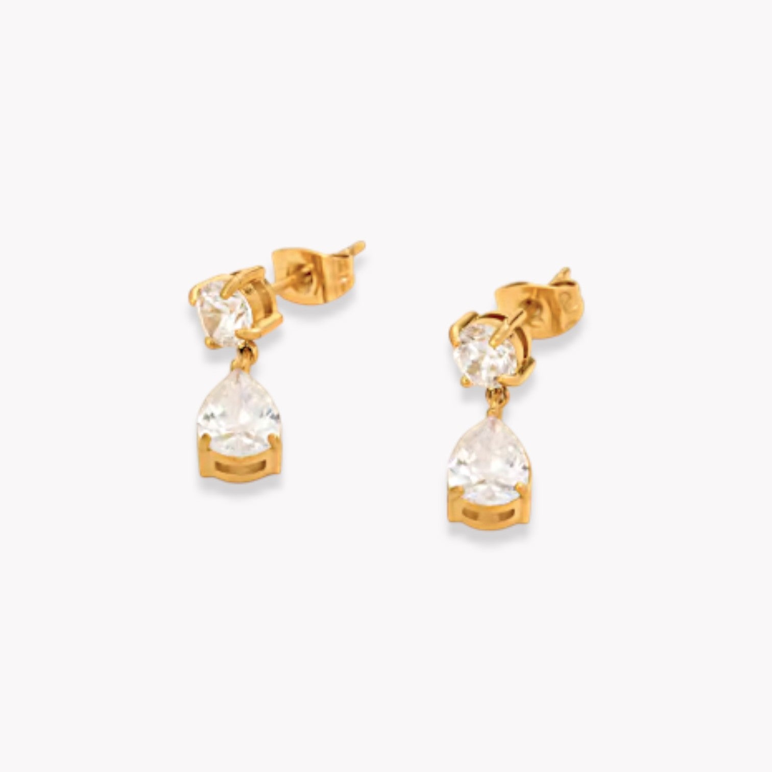 Gold earrings with clear gemstones on a white background