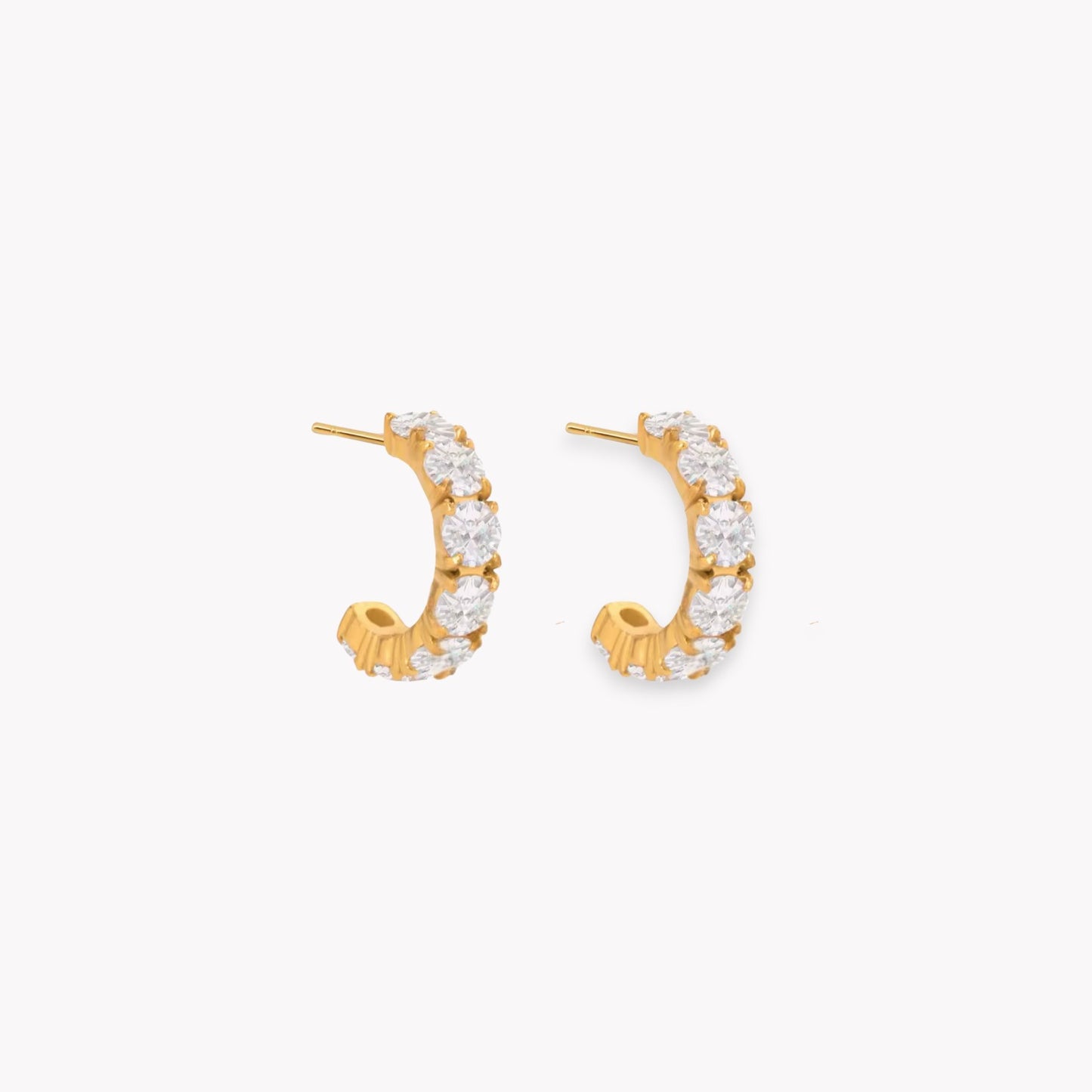 Gold hoop earrings with clear gemstones on a white background