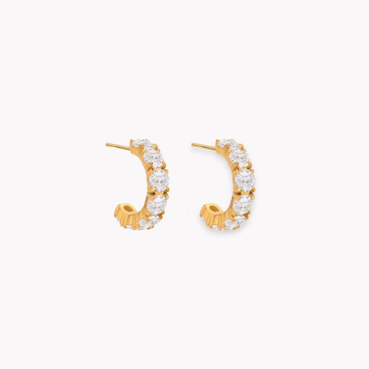 Gold hoop earrings with clear gemstones on a white background