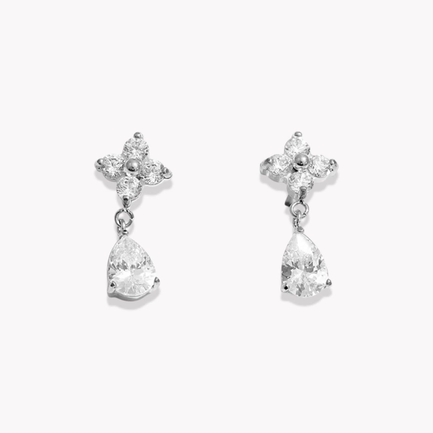 Pair of silver earrings with teardrop-shaped crystals on a white background