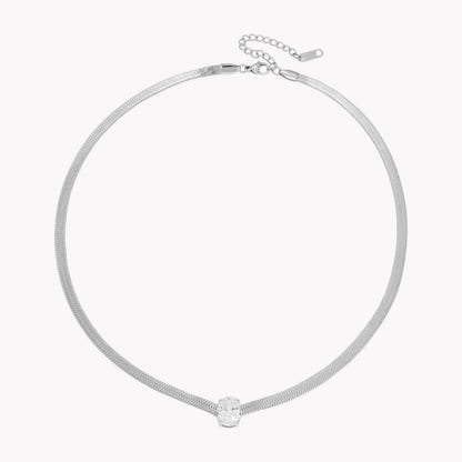 silver necklace with oval shaped gemstone pictured on a white background
