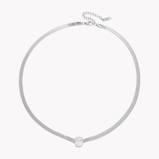 silver necklace with oval shaped gemstone pictured on a white background