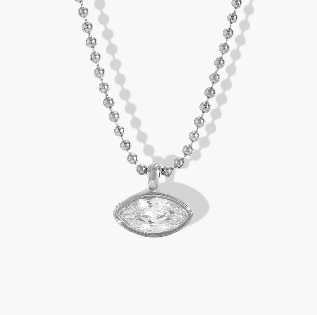 A silver beaded necklace with an oval-cut clear gemstone pendant, displayed on a clean white background with soft drop shadows.