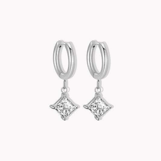 Silver hoop earrings with clear square shaped diamond pendants on a white background