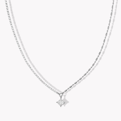 Silver necklace with a square shaped pendant on a white background