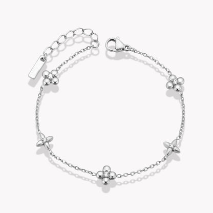 A silver bracelet with flower details, displayed against a white background.