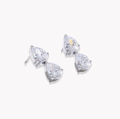 A pair of silver stud earrings featuring pear-cut clear gemstones in a prong setting, displayed on a clean white background.