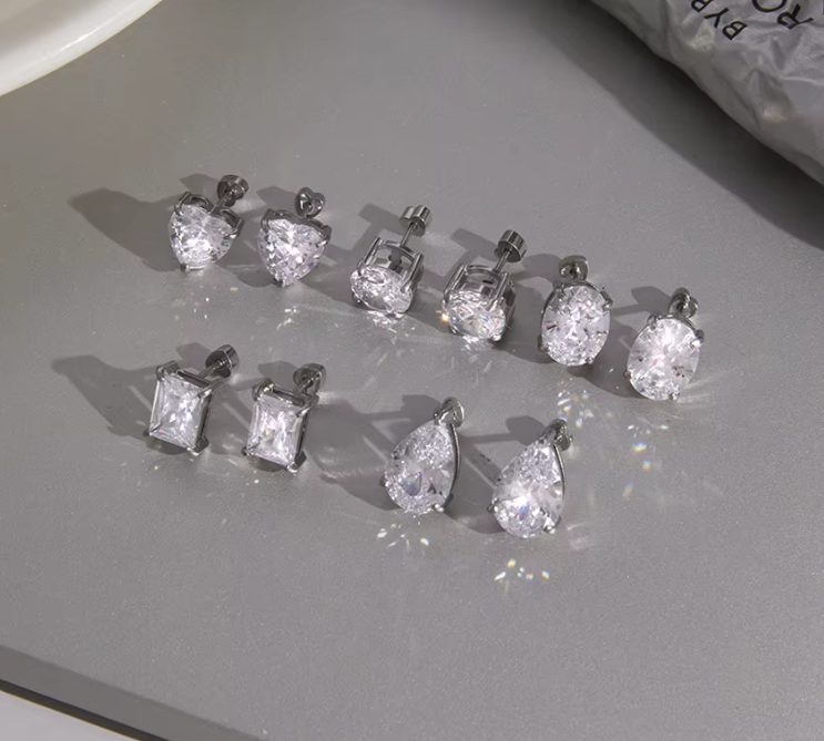 Set of diamond stud earrings on a gray surface