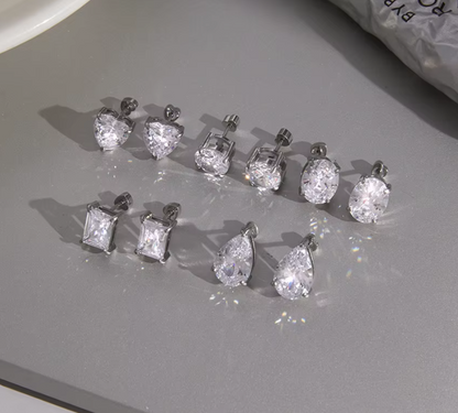 Set of diamond stud earrings on a gray surface