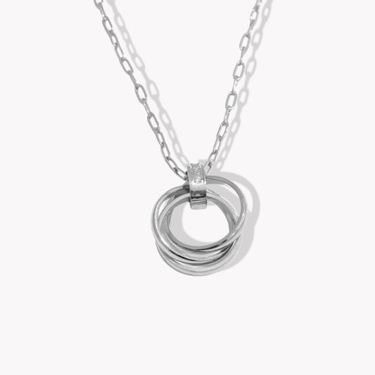 Silver necklace with interlocking rings and tiny clear gemstone detail on a white background