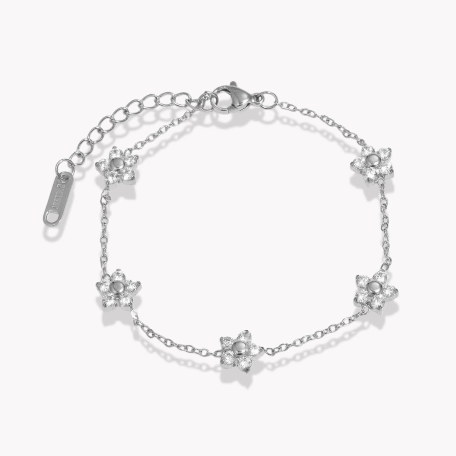 Silver bracelets with clear gemstone floral design on a white background