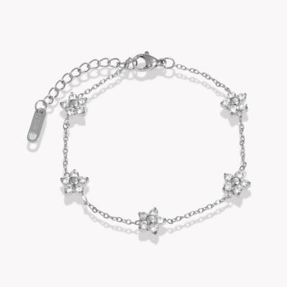 Silver bracelets with clear gemstone floral design on a white background