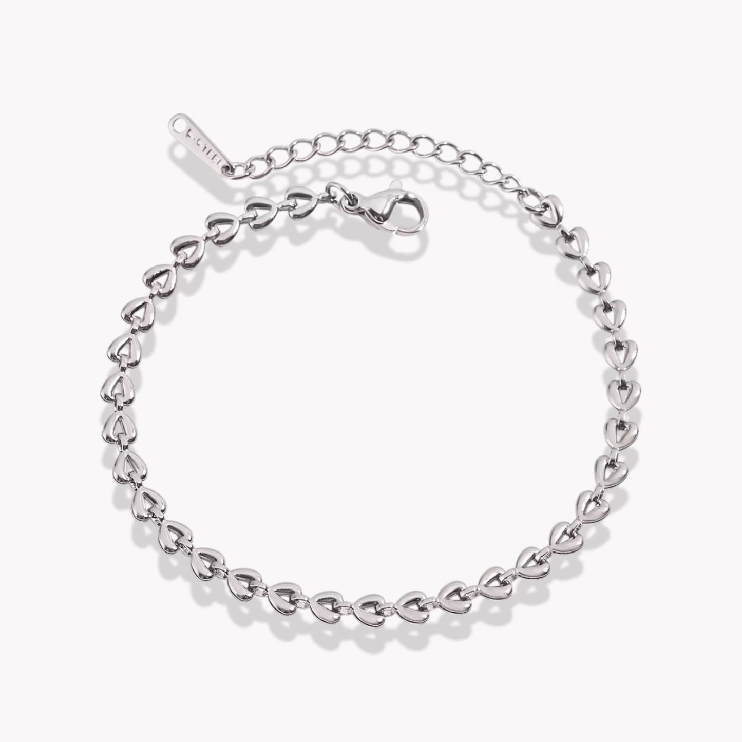 A silver bracelet with heart shaped link details, featuring a link chain design and a branded clasp.