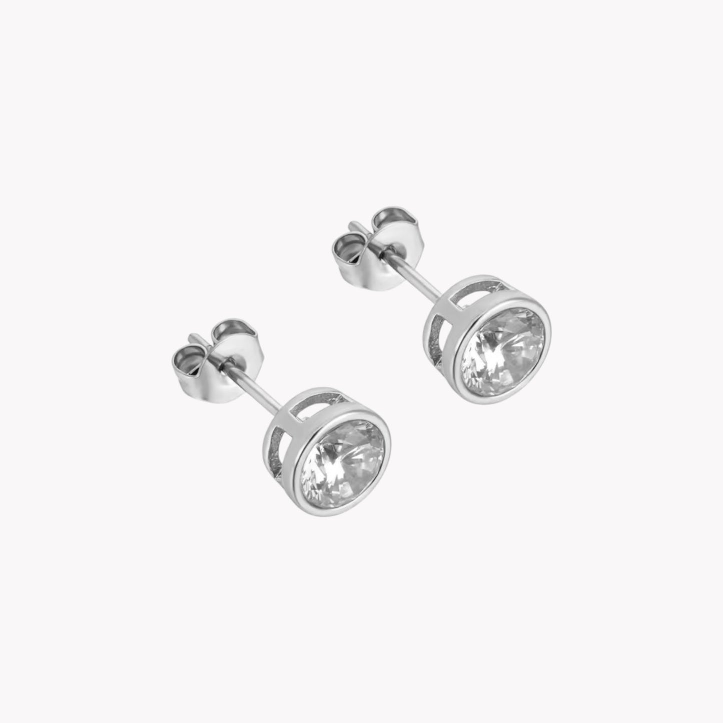 A pair of silver stud earrings with clear round gemstone pictured on a white background