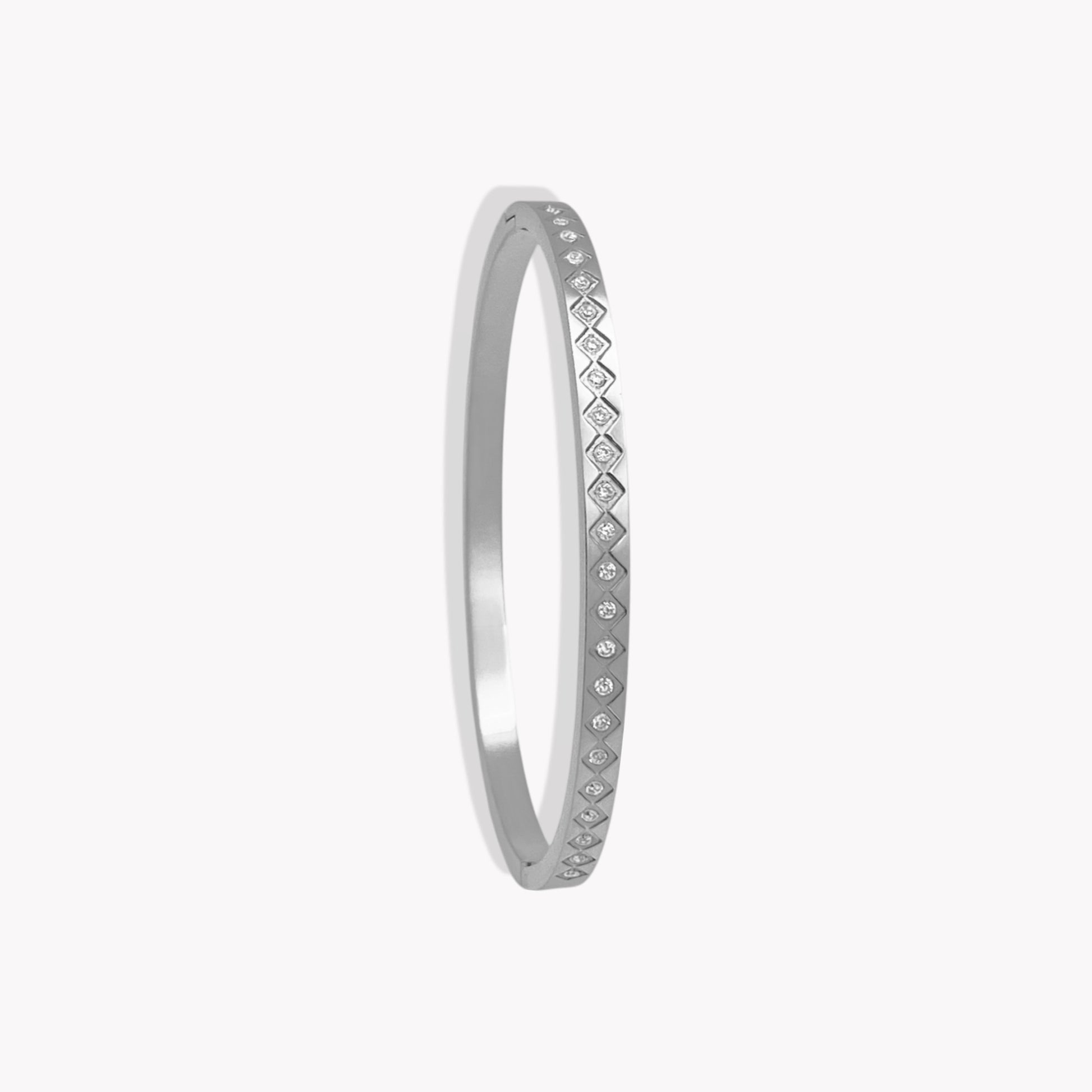 Silver bangle with small diamonds on a white background