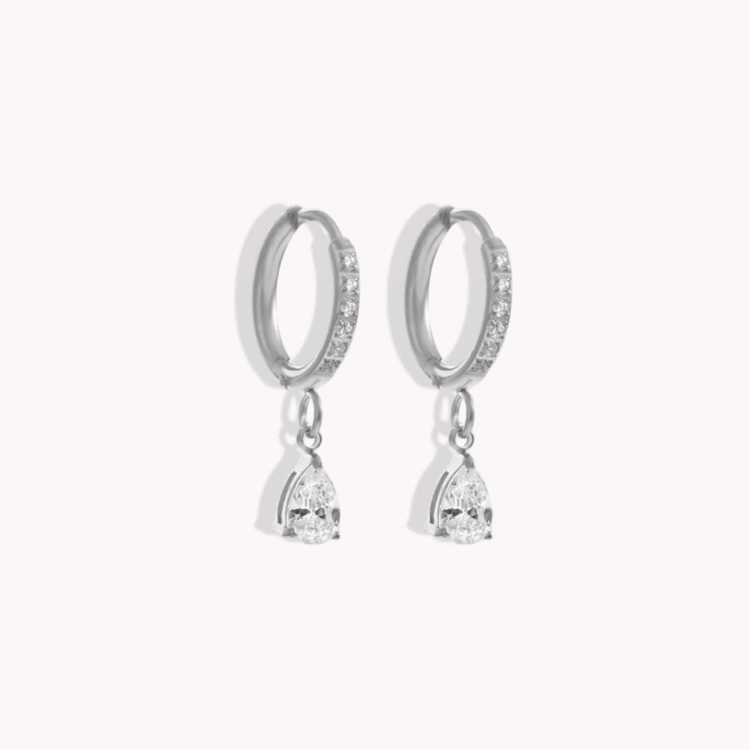 Silver hoop earrings with diamonds on the hoop and a pear shaped drop pendant on a white background