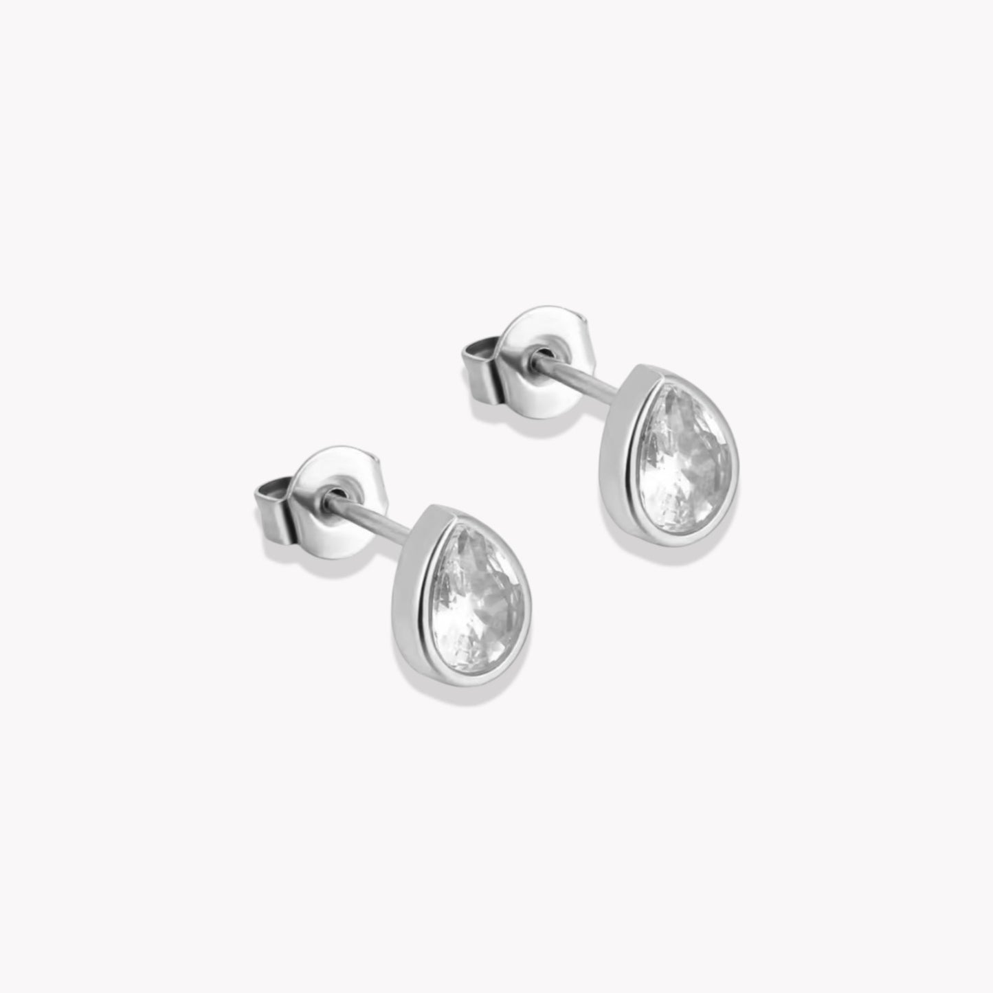 A pair of silver stud earrings with a pear shape and a central clear crystal, mounted on a white background.