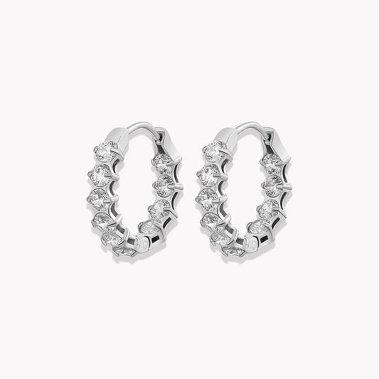 Pair of silver hooped earrings featuring beautiful clear gemstones onn the front and inside the back of the hoop. Pictured on a llight grey background