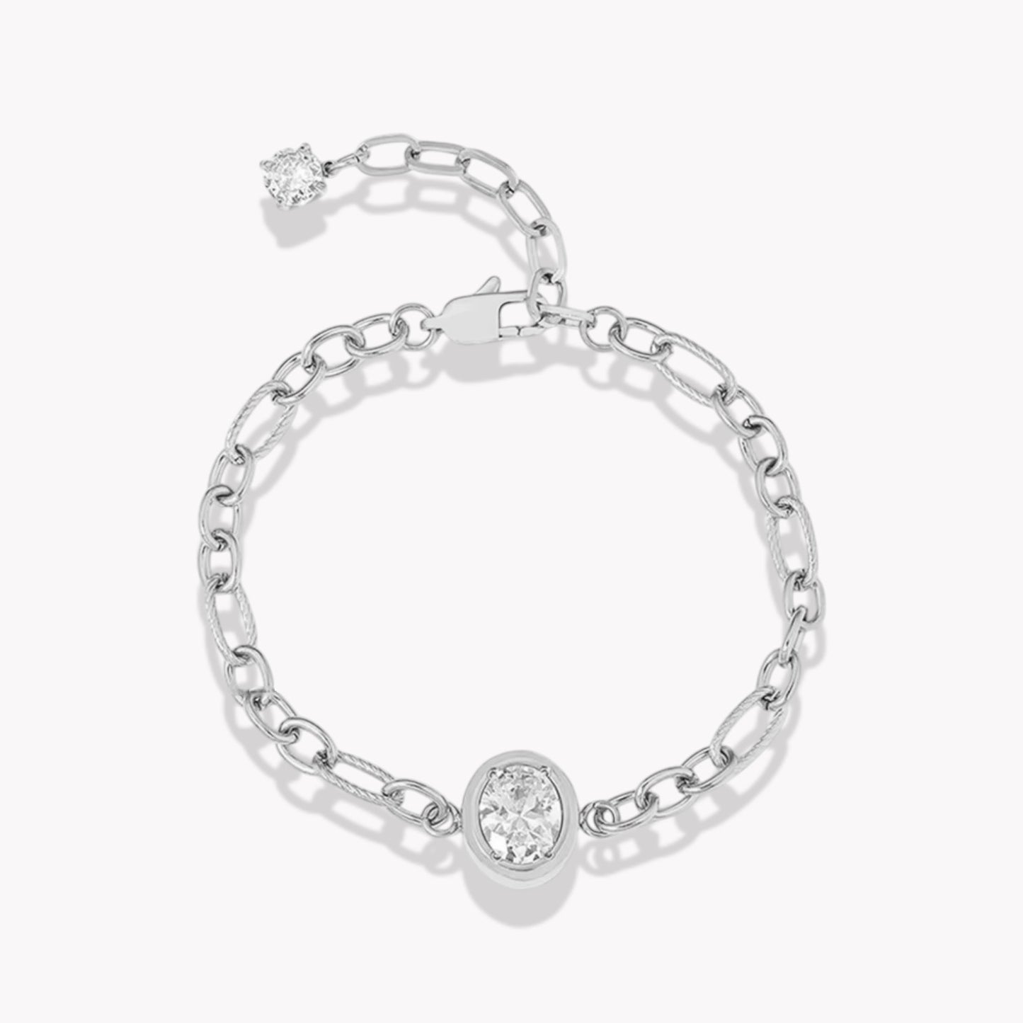 Silver chain bracelet with large central oval diamond. Bracelet has an extender with a clear gemstone on the end. Pictured on a white background