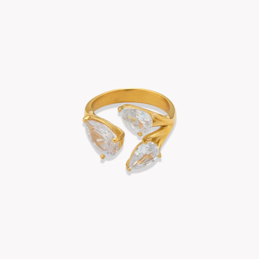 Gold ring with clear pear shaped gemstones on a white background