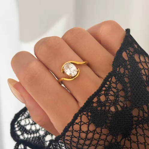 Gold ring with a large diamond on a hand wearing a black lace glove.