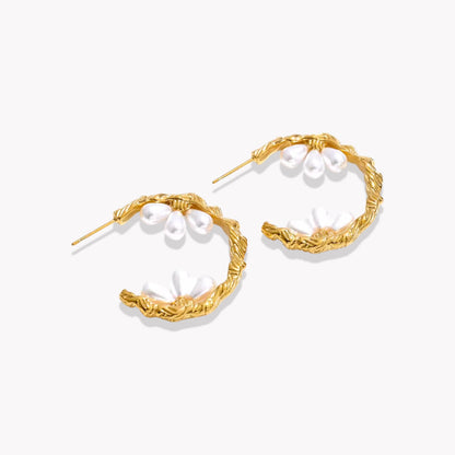 gold hooped earrings featuring pretty pearl detail photographed on a light background
