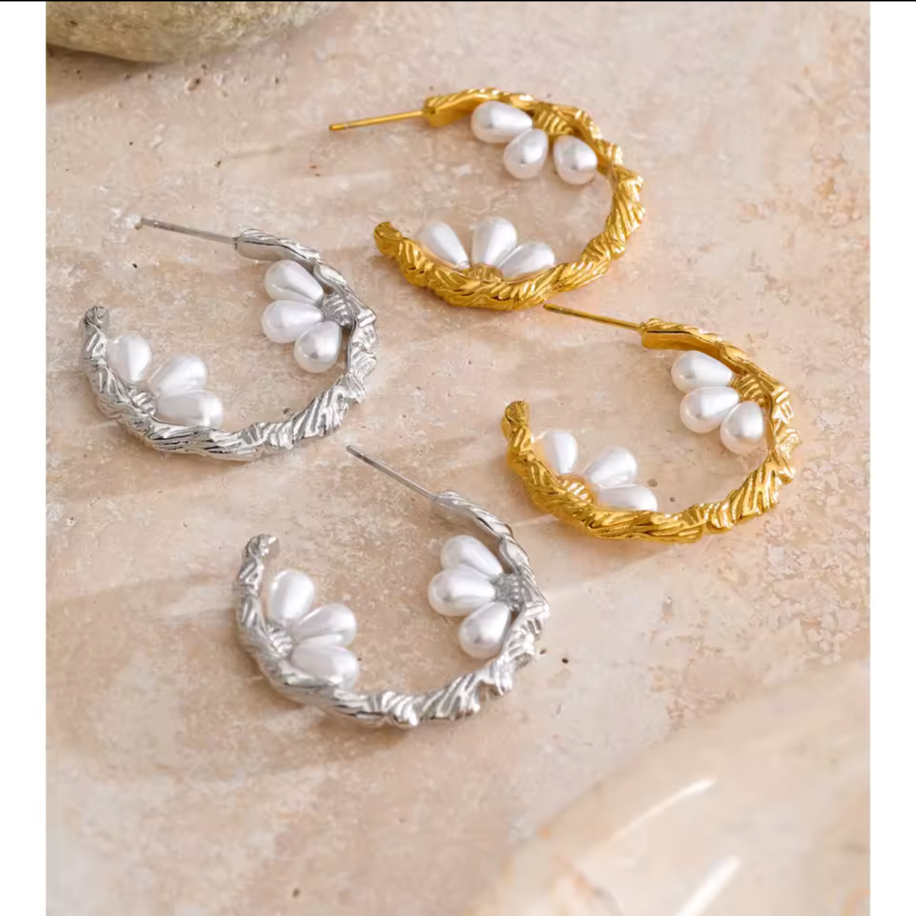 silver and gold hooped earrings featuring pretty pearl detail photographed on a light background