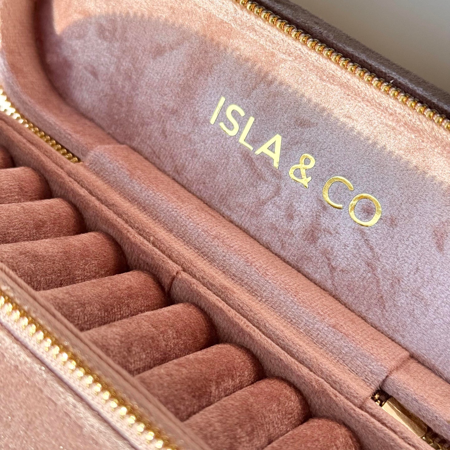 Pink jewelry case with 'ISLA & CO' branding on a light background