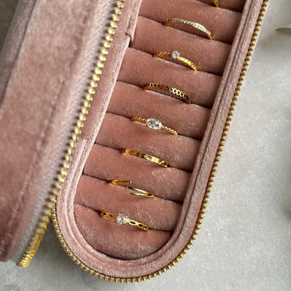Dusky Pink jewelry case with gold rings on a light grey background