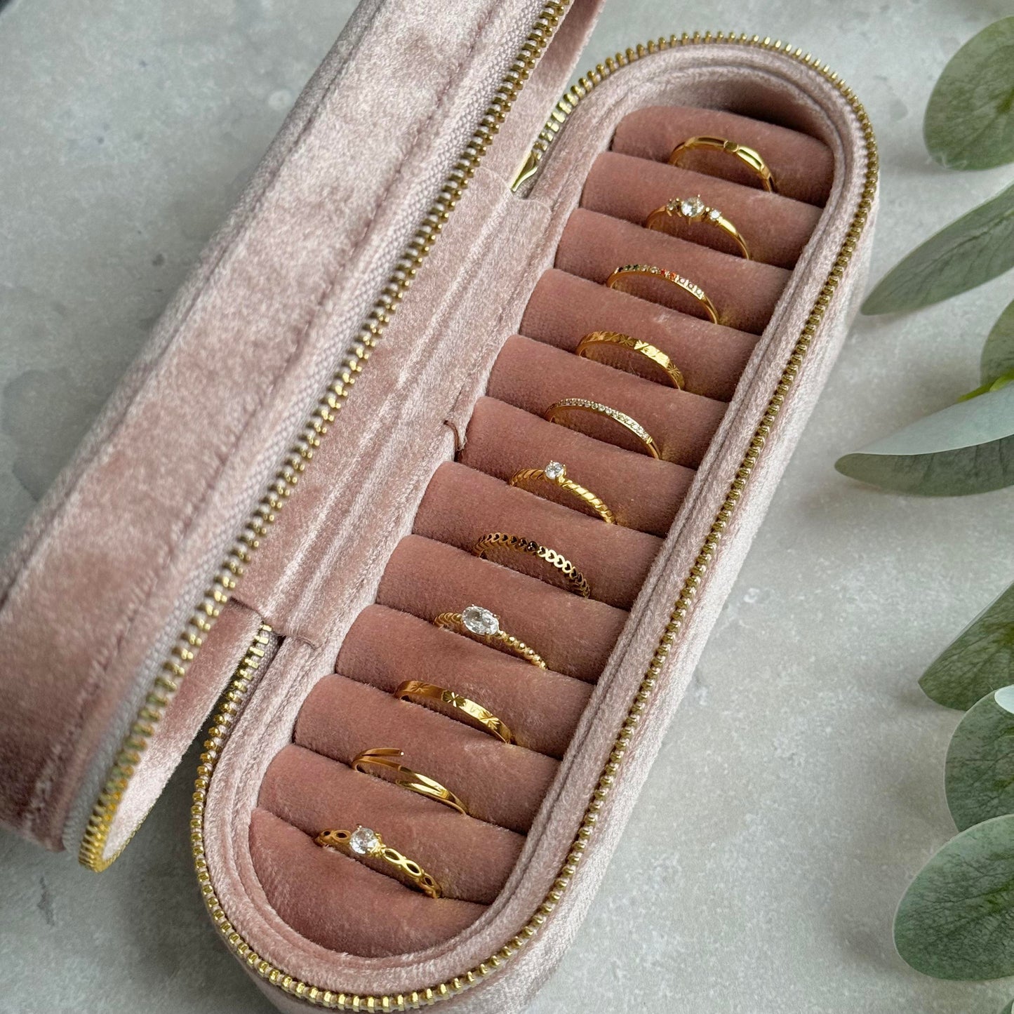 Dusky Pink jewelry case with gold rings on a light grey background