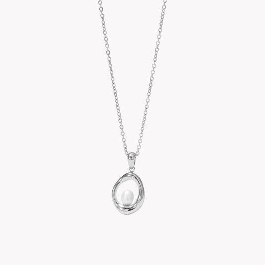 silver necklace with circular pendant featuring a small pearl inside pictured on a neutral background