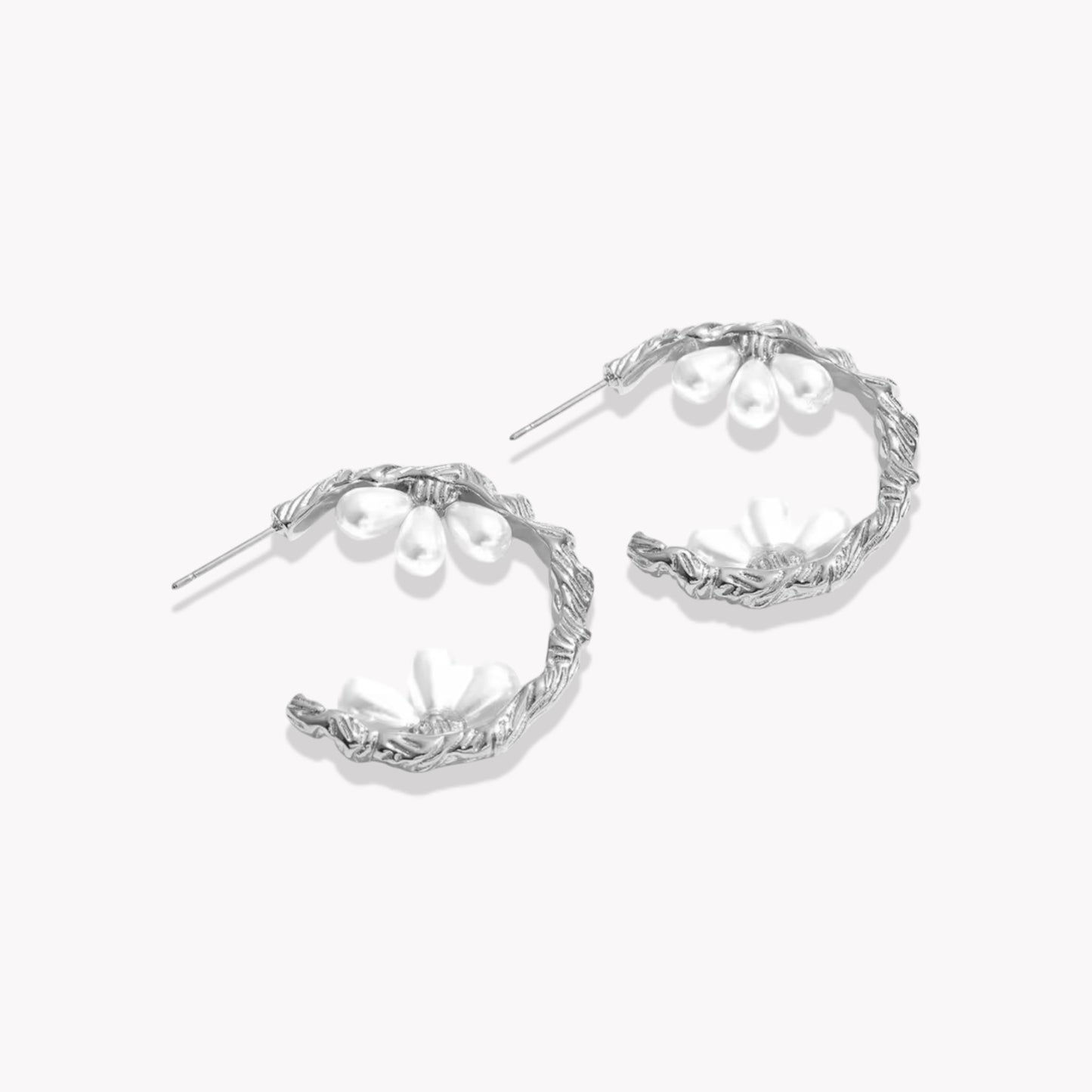silver hooped earrings featuring pretty pearl detail photographed on a light background