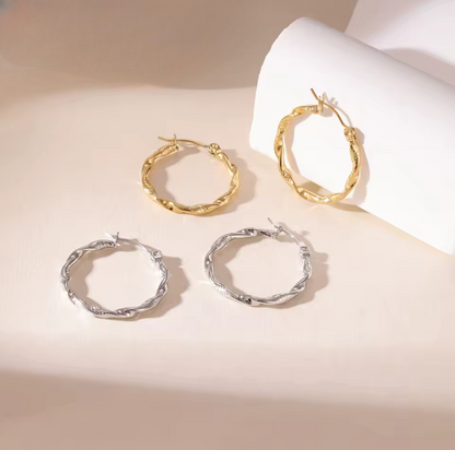 Set of gold and silver hoop earrings on a light background